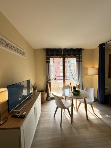 un salon avec une télévision, une table et des chaises dans l'établissement Magnifique logement au centre de Cannes POR1897, à Cannes