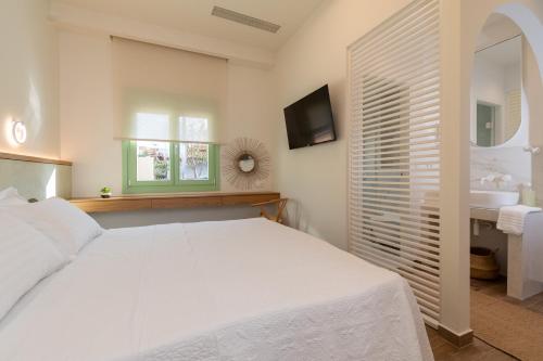 a white bedroom with a bed and a sink at Pnoe Luxury Villa in Ierissos
