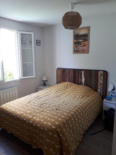 une chambre avec un lit avec une couette dessus dans l'établissement Maison 6P dans résidence avec piscine, à Châtelaillon-Plage