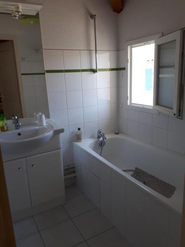 a white bathroom with a tub and a sink at Maison 6P dans résidence avec piscine in Châtelaillon-Plage