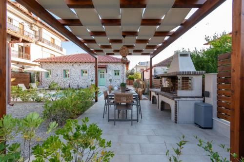 a patio with a grill and a table and a stove at Pnoe Luxury Villa in Ierissos
