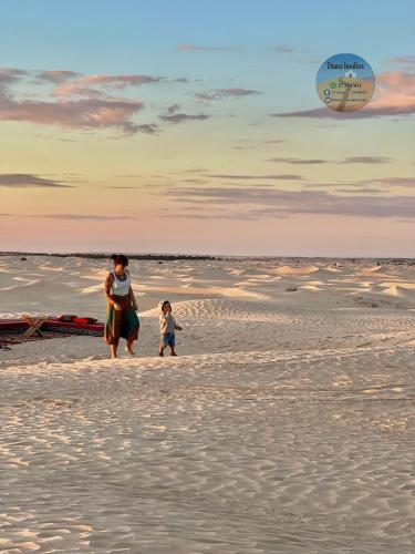 a woman and a child walking on the beach at Camp Dunes Insolites Sabria in Sabria
