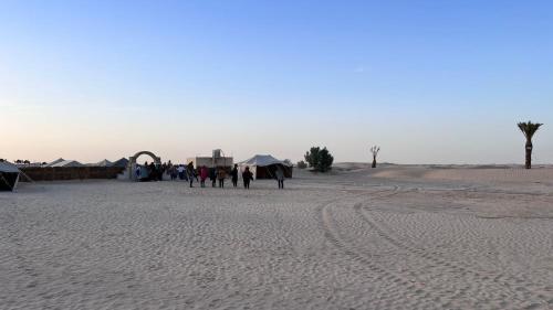 a group of people walking in the desert at Camp Dunes Insolites Sabria in Sabria