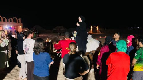 a group of people standing in a crowd at night at Camp Dunes Insolites Sabria in Sabria