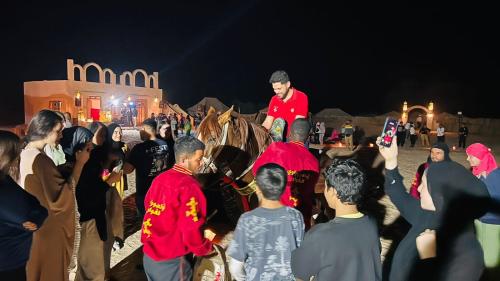 a man riding a horse in a crowd of people at Camp Dunes Insolites Sabria in Sabria