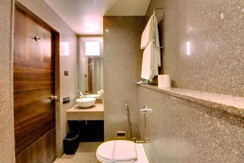 a bathroom with a toilet and a sink at SANKAMA The Boutique Hotel in Dāvangere