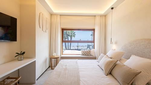 a bedroom with a bed and a large window at Chinitas Boutique Bellavista in Málaga
