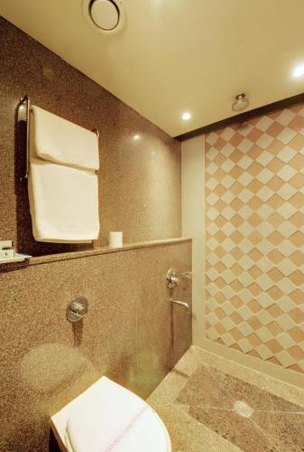 a bathroom with a toilet and a shower at SANKAMA The Boutique Hotel in Dāvangere