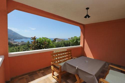 a balcony with a table and a large window at Apartmani Amra in Ivanovići