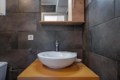 a bathroom with a white bowl sink on a wooden counter at Villa Spirida at Drakopoulata in Agia Effimia