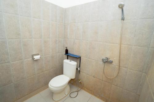 a bathroom with a toilet and a shower at RedDoorz Syariah near Lombok Epicentrum Mall in Mataram