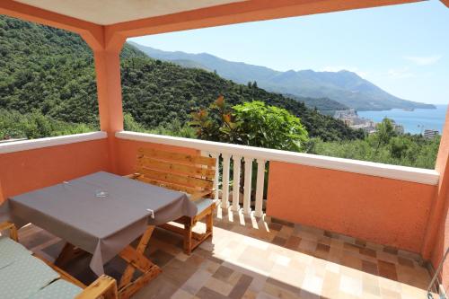 a balcony with a table and bench and a view at Apartmani Amra in Ivanovići