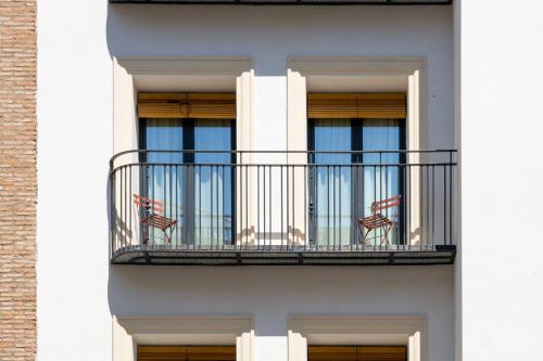 a white building with a balcony with chairs on it at Ocean Drive Sevilla in Seville