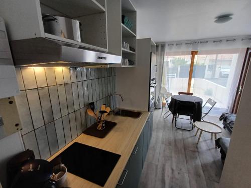 une cuisine avec un comptoir et une salle à manger dans l'établissement La chaumière en bord de mer, à Les Sables-dʼOlonne