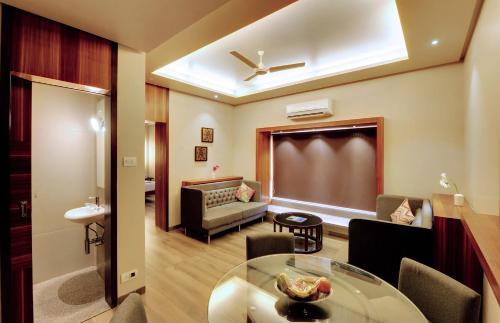 a living room with a table and a couch at SANKAMA The Boutique Hotel in Dāvangere