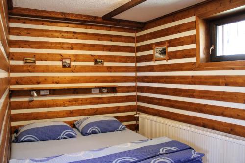 a room with wooden walls and a bed in it at Pension H in Jáchymov