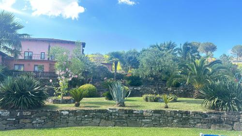 a garden with palm trees and a stone wall at Agriturismo solare in Perito