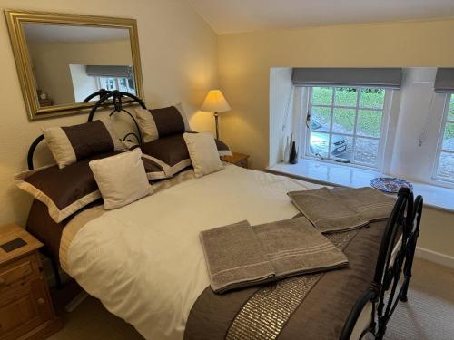 a bedroom with a large bed with a mirror at Stunning cottage - 3 Bedrooms & 3 Bathrooms in Bakewell