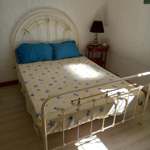 un lit blanc avec des oreillers bleus et des oreillers bleus dans l'établissement appartement 60m2, 15km mer 2lits parking gratuit, à Montblanc