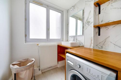 a laundry room with a sink and a washing machine at Welcome to Karl House in Champigny-sur-Marne