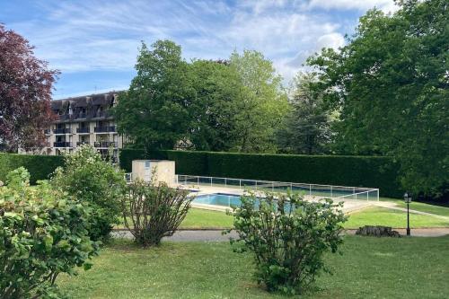 un jardin avec une piscine et un bâtiment dans l'établissement La Parenthèse Normande, à Villers-sur-Mer