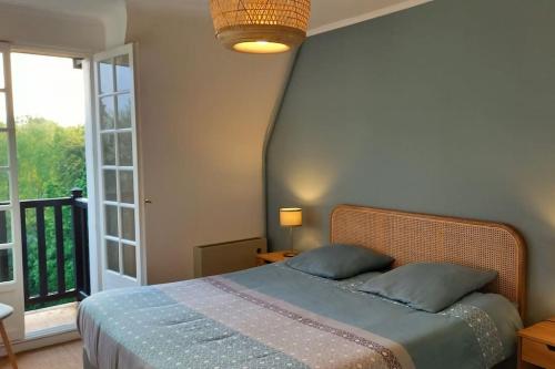 une chambre avec un lit et une grande fenêtre dans l'établissement La Parenthèse Normande, à Villers-sur-Mer