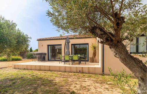 une maison avec un patio avec une table et des chaises dans l'établissement 3 Bedroom Amazing Home In Bellegarde, à Bellegarde