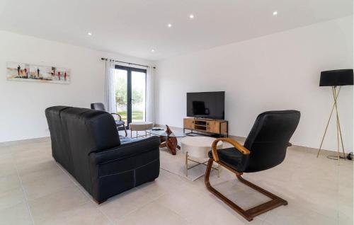 un salon avec deux chaises et une télévision dans l'établissement 3 Bedroom Amazing Home In Bellegarde, à Bellegarde