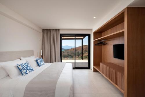 a bedroom with a large bed and a television at Villa Cristina in Elounda