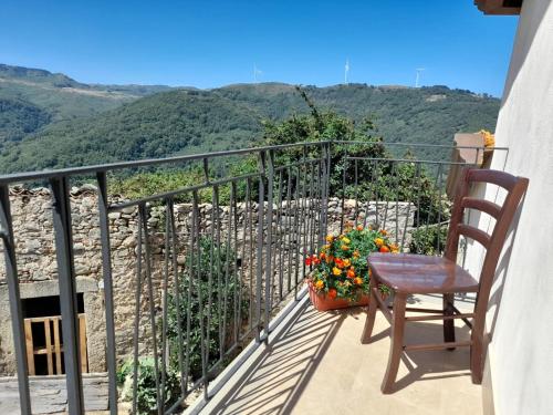 a chair and a table on a balcony with mountains at Albergo Diffuso Montalbano Borgo Antico - La Casetta del Vento in Montalbano Elicona