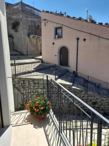 a building with a balcony with a flower pot at Albergo Diffuso Montalbano Borgo Antico - La Casetta del Vento in Montalbano Elicona