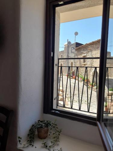 a window with a plant next to a balcony at Albergo Diffuso Montalbano Borgo Antico - La Casetta del Vento in Montalbano Elicona