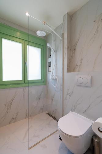 a bathroom with a toilet and a glass shower at Pnoe Luxury Villa in Ierissos