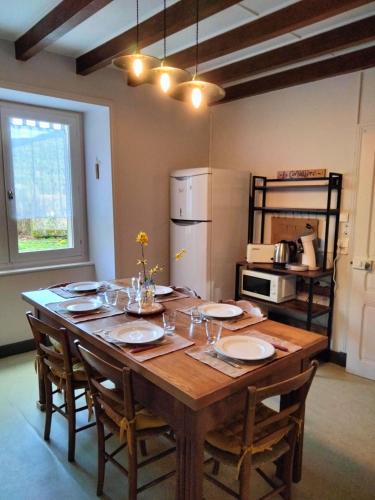 une grande table en bois avec des chaises et une cuisine dans l'établissement Maison Vintage, à Marat