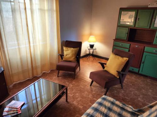 un salon avec deux chaises et une table basse dans l'établissement Maison Vintage, à Marat