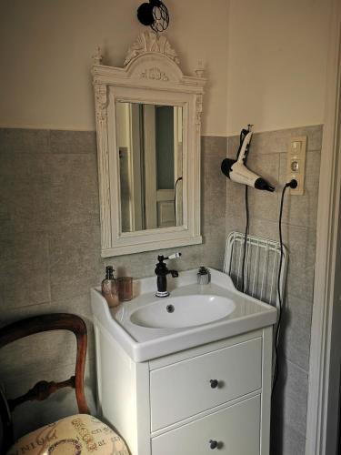 a bathroom with a white sink and a mirror at Kúria Apartman Budapest with free parking in Budapest