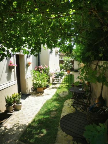 a garden with a table and chairs and plants at Kúria Apartman Budapest with free parking in Budapest