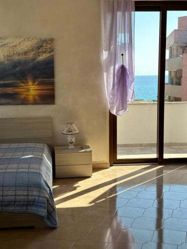 a bedroom with a bed and a view of the ocean at Dimora Signore Gallipoli lido in Gallipoli