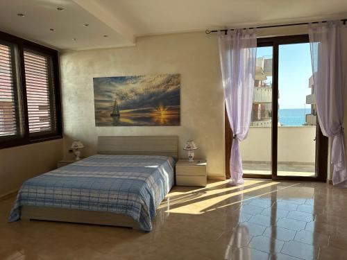 a bedroom with a bed and a view of the ocean at Dimora Signore Gallipoli lido in Gallipoli