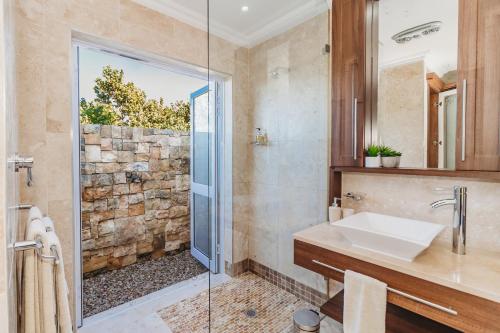 Un baño con ducha de cristal y lavabo. en GolfersHeaven Kingswood Golf Estate, en George
