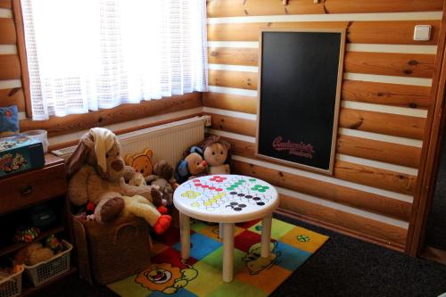 a corner of a room with a table and stuffed animals at Pension H in Jáchymov