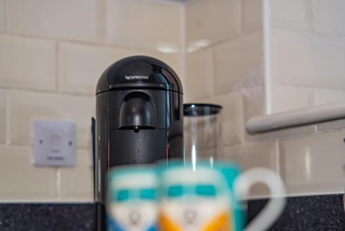 a coffee maker sitting on a counter next to a cup at Two bedroom Newcastle City Quayside Apartment in Newcastle upon Tyne