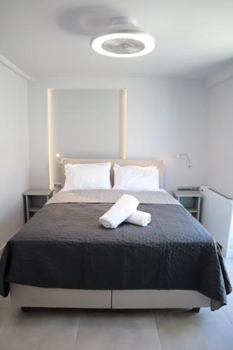 a bedroom with a bed with a black comforter at Golden Sand Suites in Anavissos