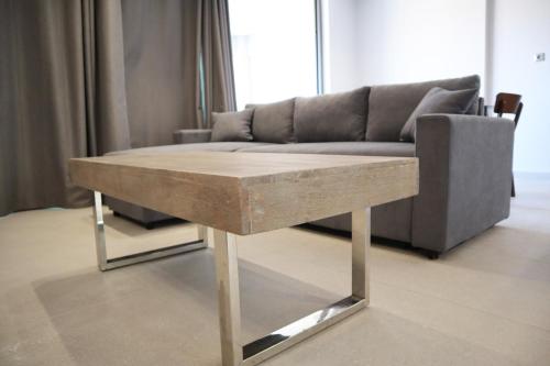 a wooden table in a living room with a couch at Golden Sand Suites in Anavissos