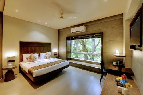 a bedroom with a large bed and a window at SANKAMA The Boutique Hotel in Dāvangere
