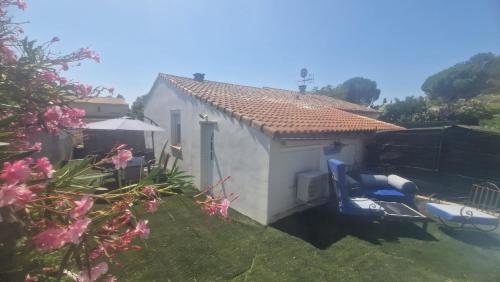 une petite maison avec une chaise bleue dans une cour dans l'établissement Maisonnette avec jardin et piscine privée, à Grabels