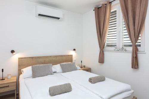 a bedroom with two beds and a window at Villa THALIA in Tisno