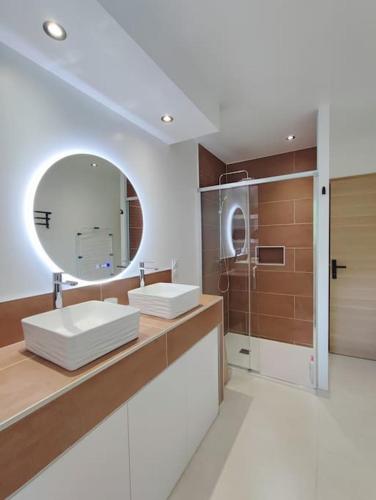 une salle de bain avec deux lavabos et un miroir dans l'établissement Le Lodge de St Sauveur, à Esquennoy