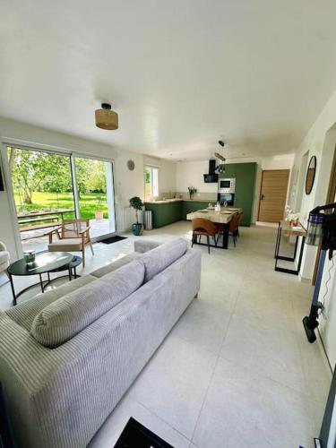 un salon avec un canapé et une table dans l'établissement Le Lodge de St Sauveur, à Esquennoy