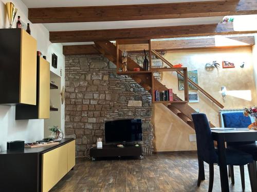 a living room with a stone wall and a staircase at Maison Gaia in Velletri